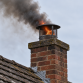Chimney fire with smoke coming from a house chimney